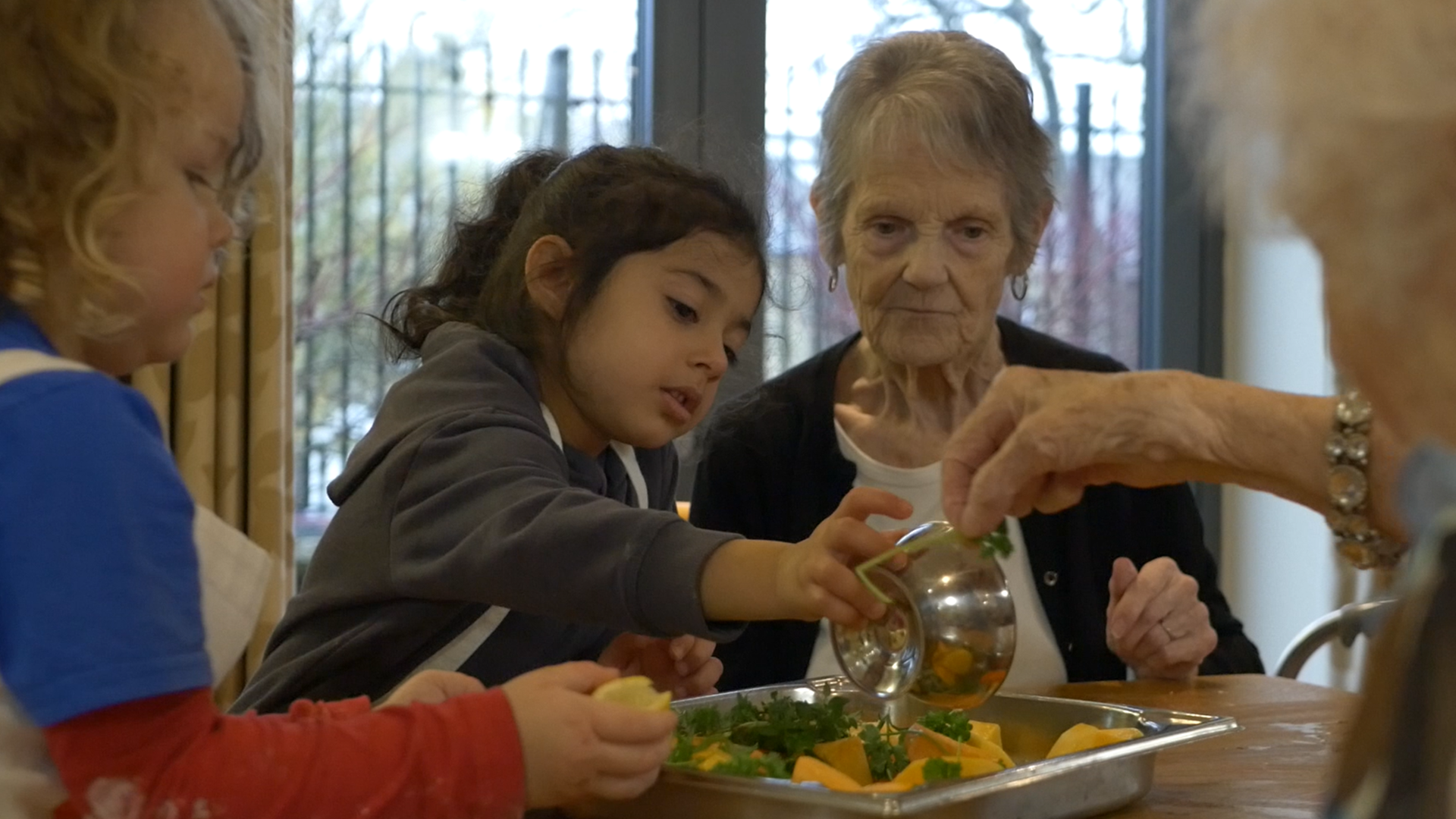Older people and early years children cooking together