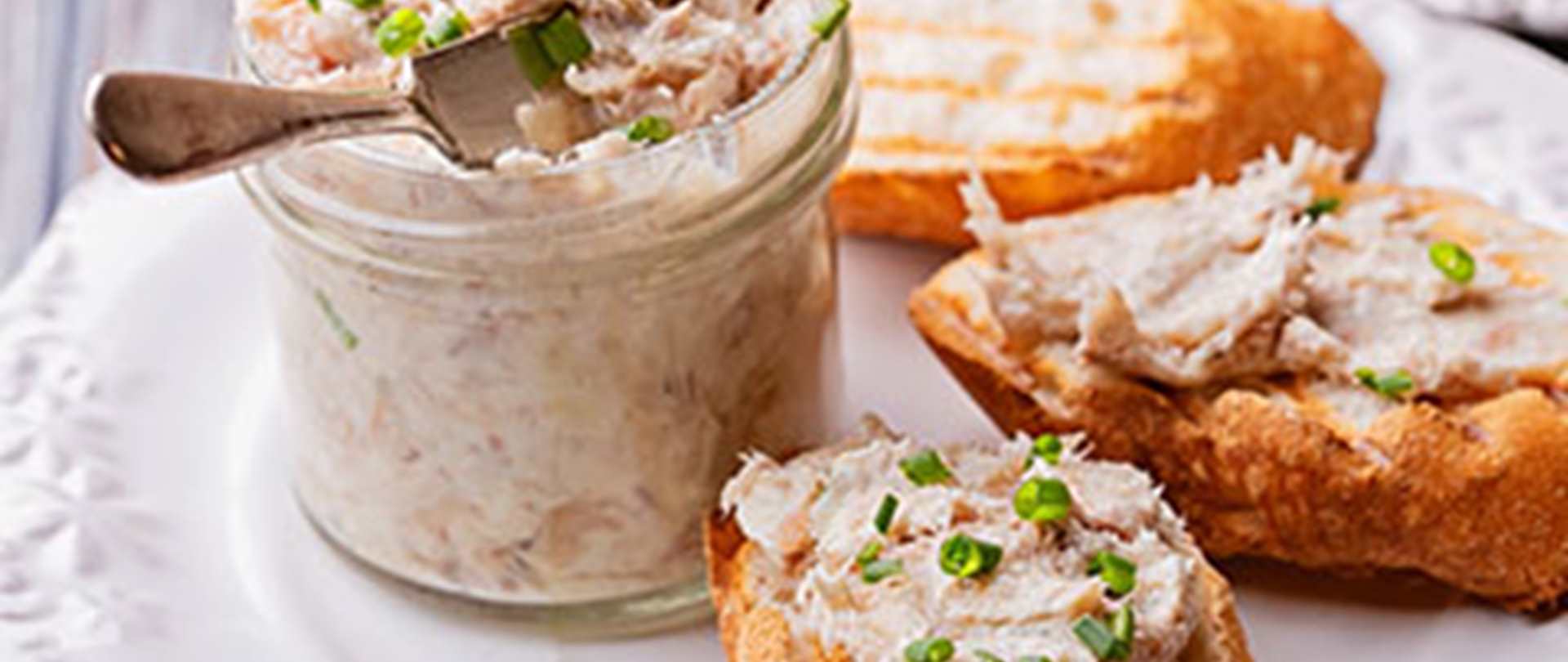 a pot of smoked mackerel pate with some spread on bread