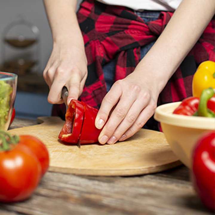 Hands chopping a red pepper