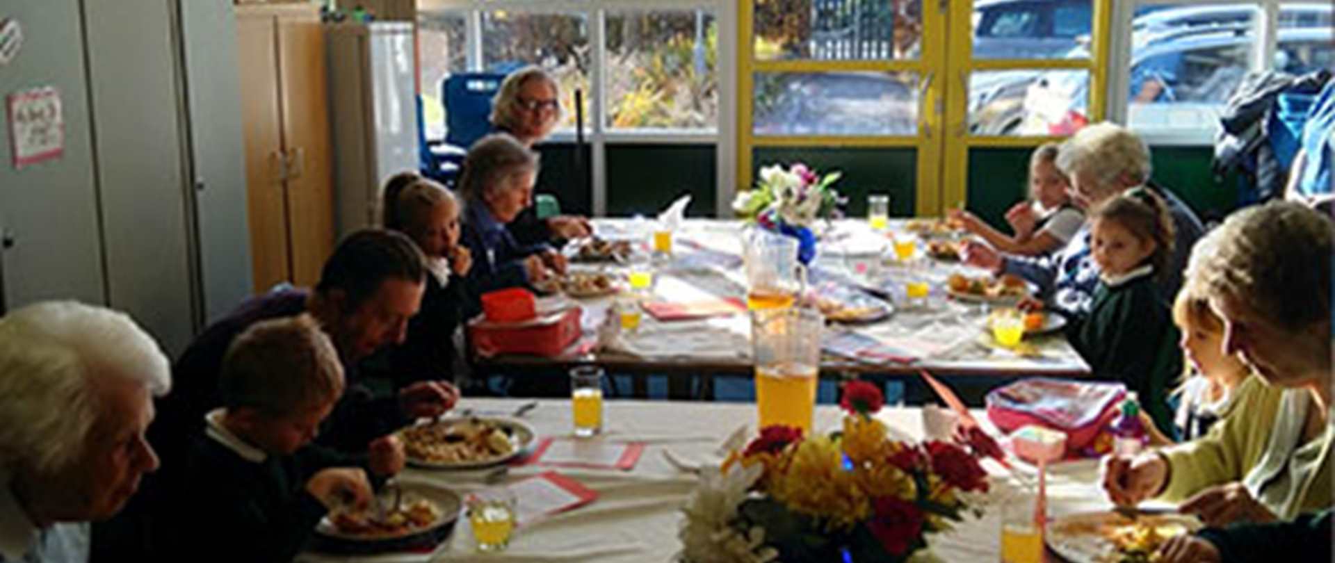 A group of children and adults enjoying a meal together at a community cafe