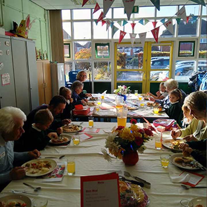 A group of children and adults enjoying a meal together at a community cafe