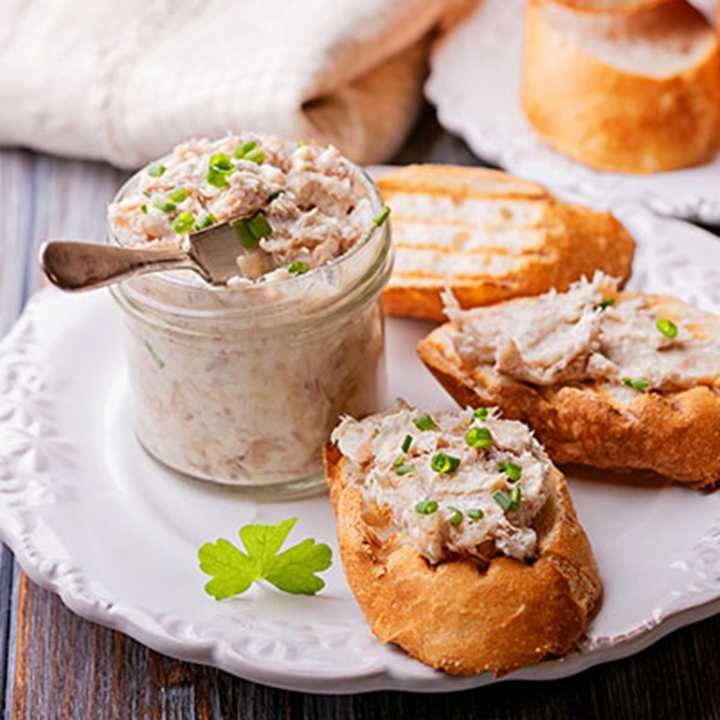 a pot of smoked mackerel pate with some spread on bread